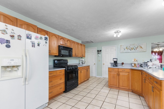 kitchen with a textured ceiling, ceiling fan, sink, black appliances, and light tile patterned floors