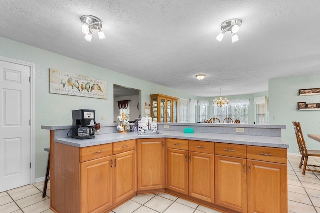 kitchen featuring a textured ceiling, a notable chandelier, and light tile patterned flooring