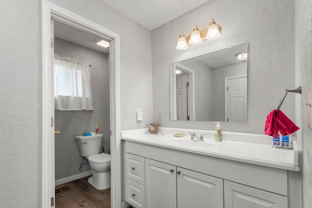 bathroom with hardwood / wood-style flooring, vanity, and toilet