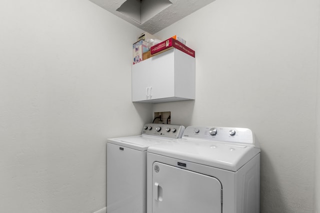 clothes washing area with cabinets and independent washer and dryer