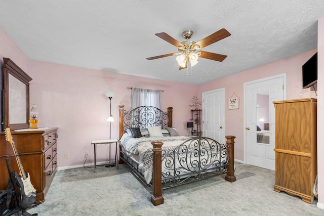 carpeted bedroom featuring a textured ceiling and ceiling fan