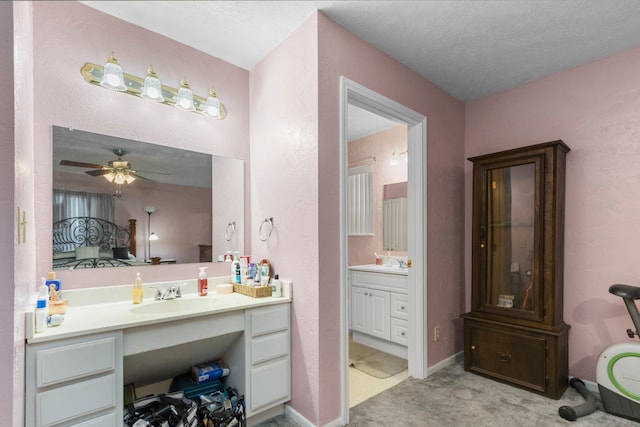 bathroom with vanity, ceiling fan, and a textured ceiling