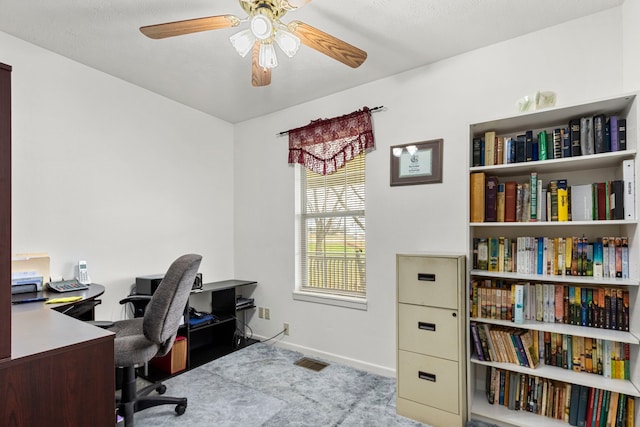 carpeted home office featuring ceiling fan