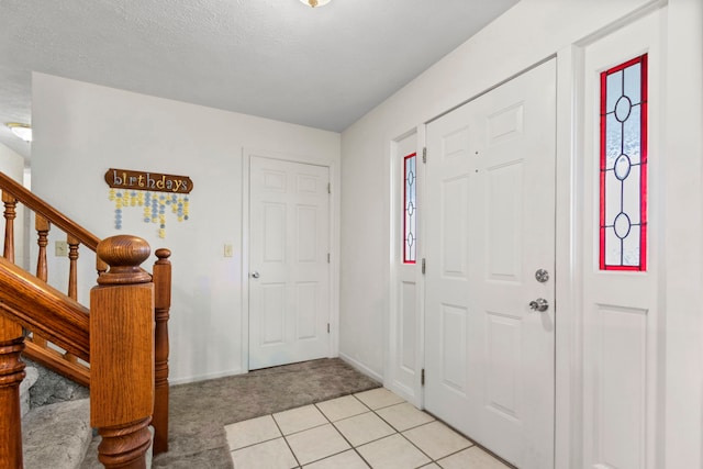 tiled entrance foyer featuring a textured ceiling