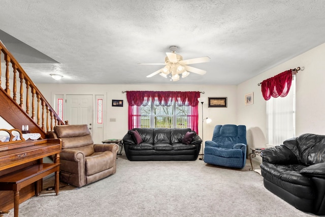 living room featuring carpet flooring, ceiling fan, and a textured ceiling