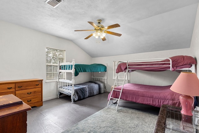 bedroom featuring a textured ceiling, vaulted ceiling, and ceiling fan