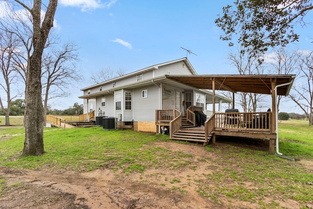 back of house with central AC, a deck, and a lawn