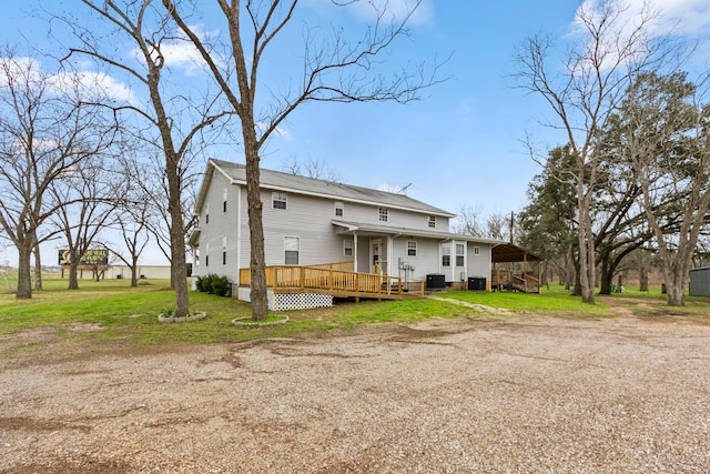 rear view of house featuring a carport, a deck, a yard, and central air condition unit