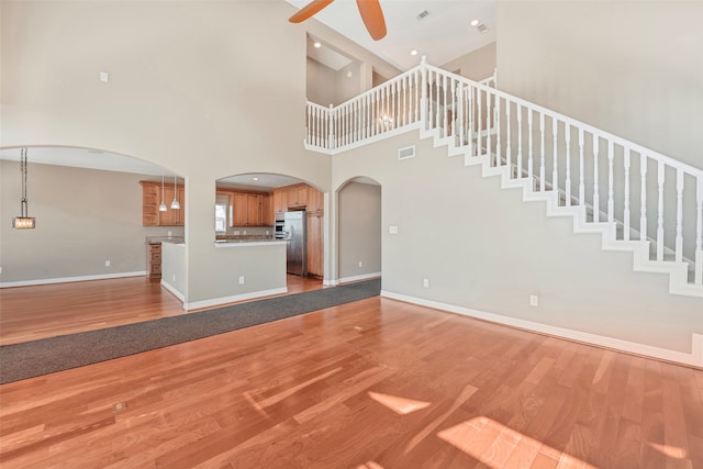 unfurnished living room with ceiling fan and light wood-type flooring