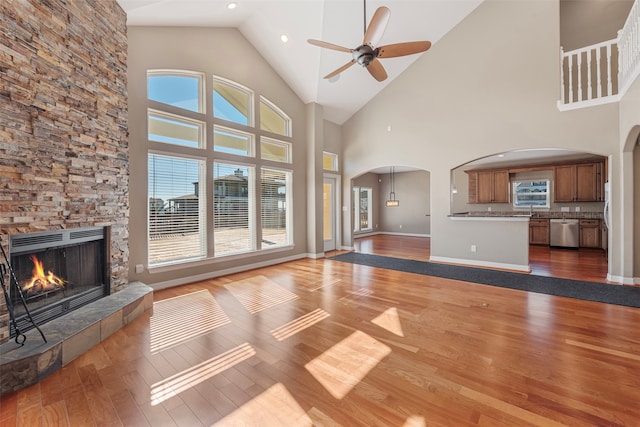 unfurnished living room with ceiling fan, wood-type flooring, a fireplace, and sink