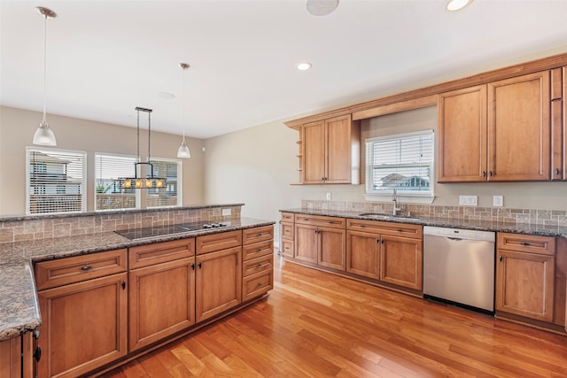 kitchen featuring sink, hanging light fixtures, black electric stovetop, light hardwood / wood-style floors, and stainless steel dishwasher