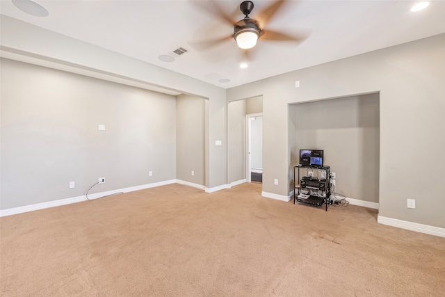 unfurnished living room with light colored carpet and ceiling fan