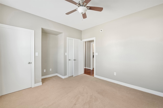 unfurnished bedroom featuring light carpet and ceiling fan