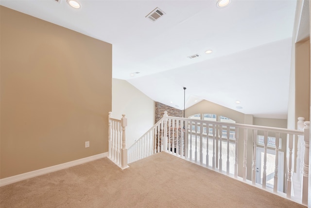 hall featuring vaulted ceiling and carpet flooring