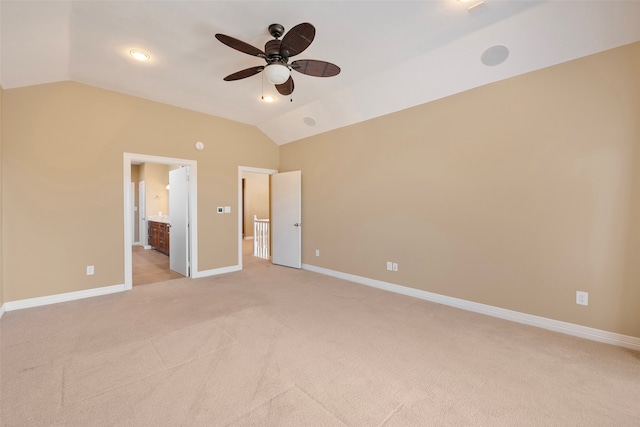 unfurnished bedroom with light carpet, connected bathroom, vaulted ceiling, and ceiling fan