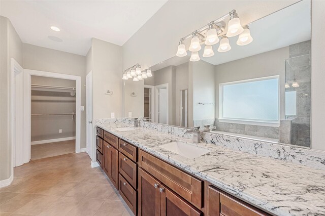 bathroom featuring tile patterned flooring, vanity, a shower, and a notable chandelier