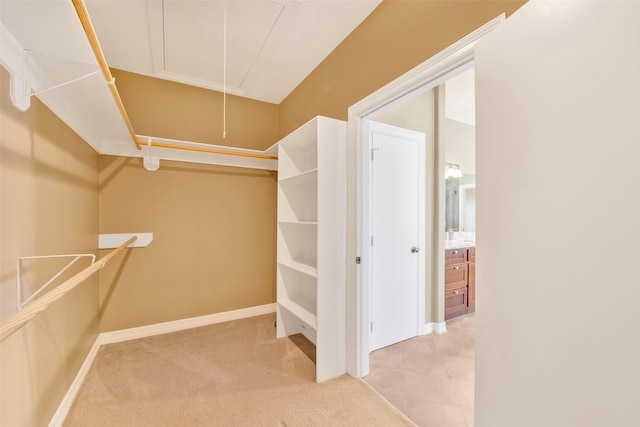 walk in closet with light colored carpet