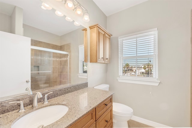 bathroom featuring plenty of natural light, toilet, an enclosed shower, and vanity