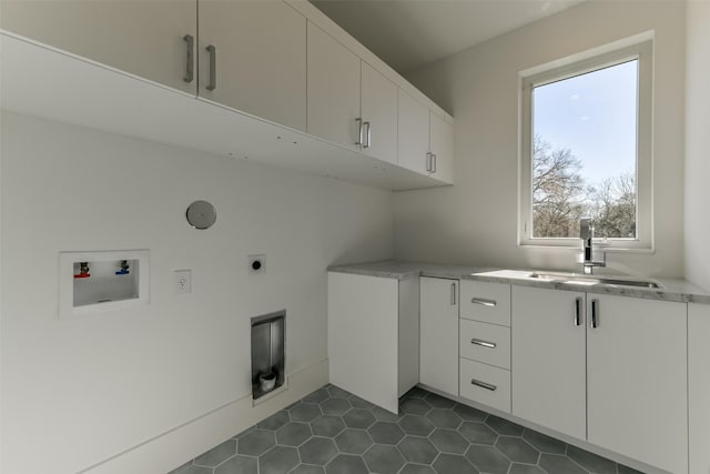 laundry area featuring cabinets, washer hookup, hookup for an electric dryer, dark tile patterned floors, and sink