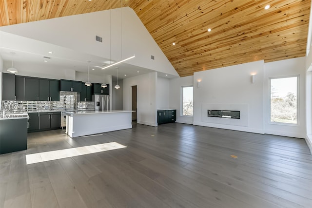 kitchen with a center island, high vaulted ceiling, stainless steel appliances, and dark hardwood / wood-style floors