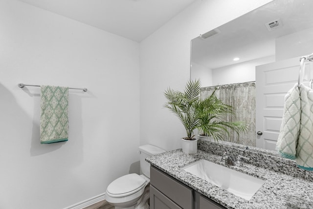 bathroom with a shower with curtain, vanity, and toilet