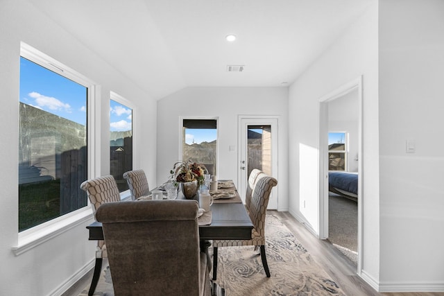 dining area featuring light hardwood / wood-style floors and lofted ceiling