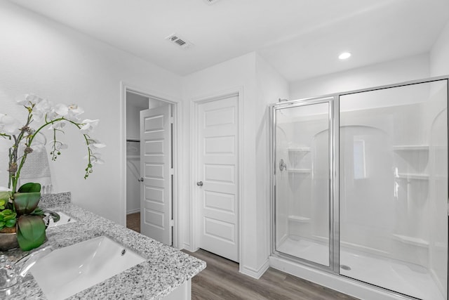 bathroom featuring vanity, a shower with shower door, and wood-type flooring