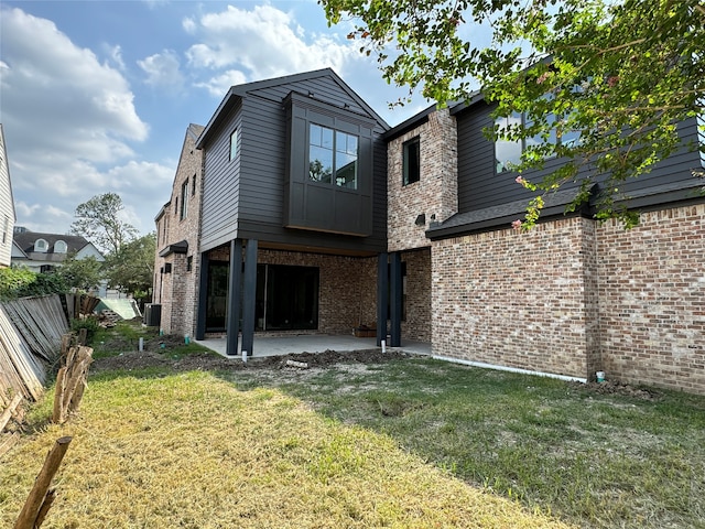 back of house with a patio area and a lawn