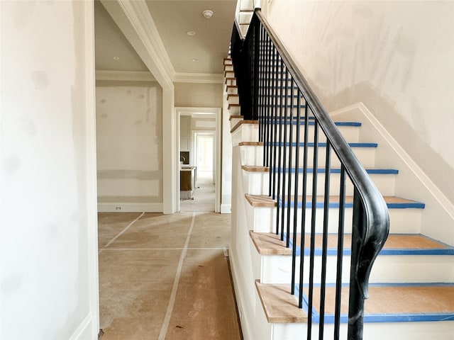 stairway featuring concrete floors and ornamental molding