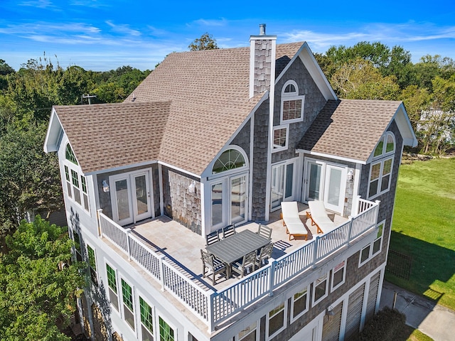 back of house with french doors and a yard