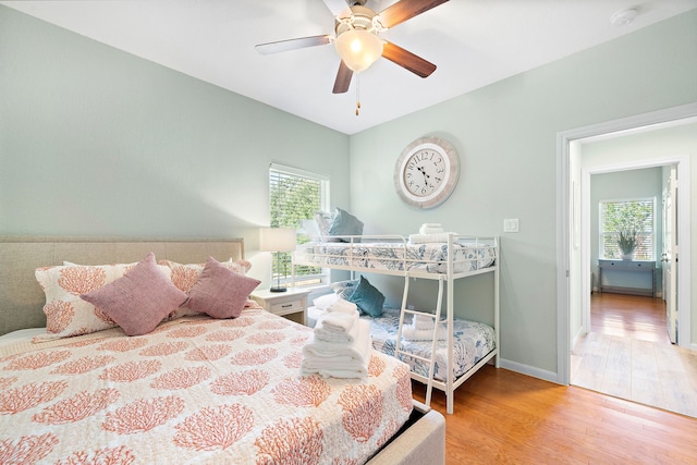 bedroom featuring multiple windows, ceiling fan, and light wood-type flooring