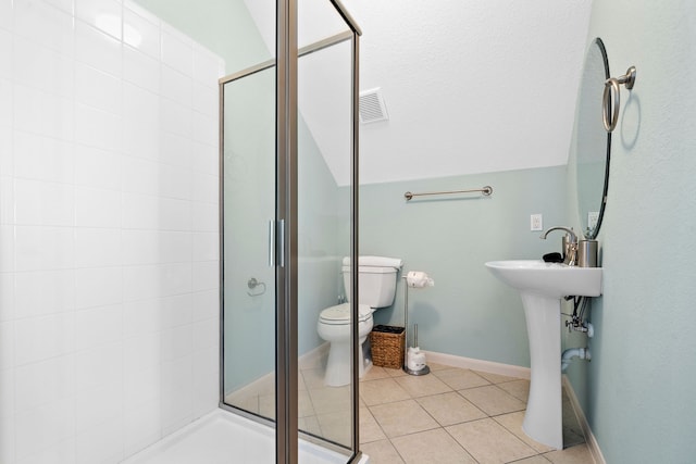 bathroom featuring tile floors, toilet, and a shower with door