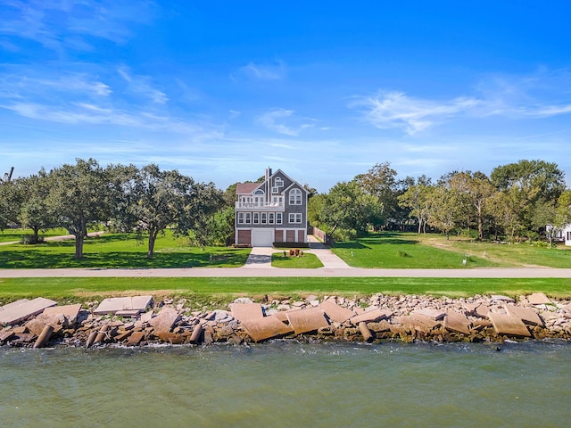 view of home's community with a water view and a yard