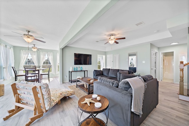 living room featuring light hardwood / wood-style flooring, ceiling fan, and a wealth of natural light