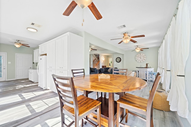 dining room with ceiling fan and light hardwood / wood-style flooring