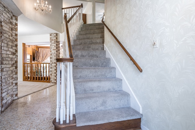 stairs with a notable chandelier