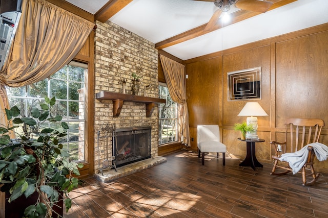 living room with dark hardwood / wood-style floors, a fireplace, brick wall, beam ceiling, and wooden walls