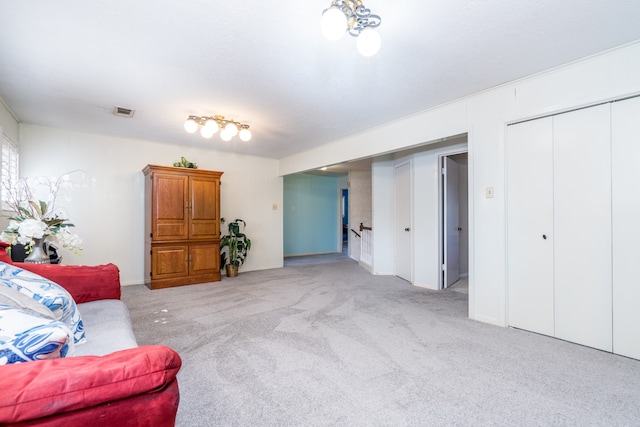 living room with a chandelier, light carpet, and rail lighting