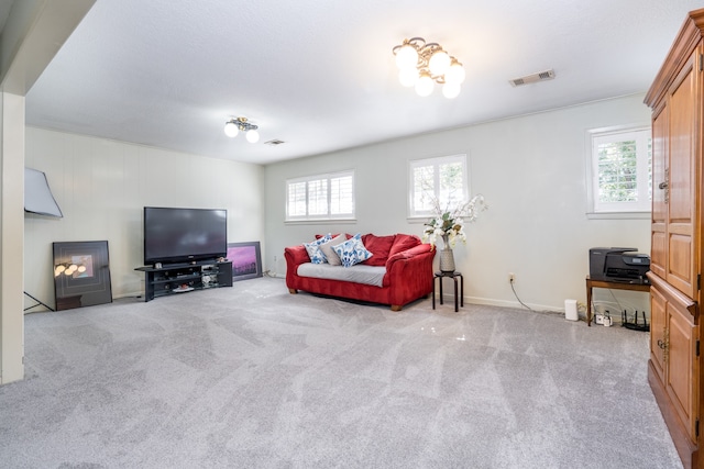 carpeted living room featuring an inviting chandelier and a healthy amount of sunlight