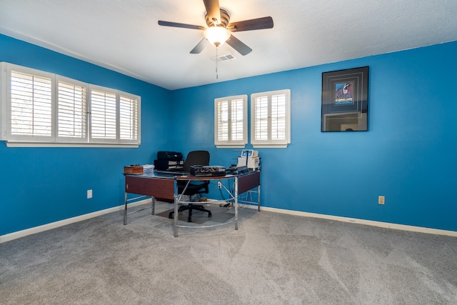 carpeted office space featuring ceiling fan and a textured ceiling