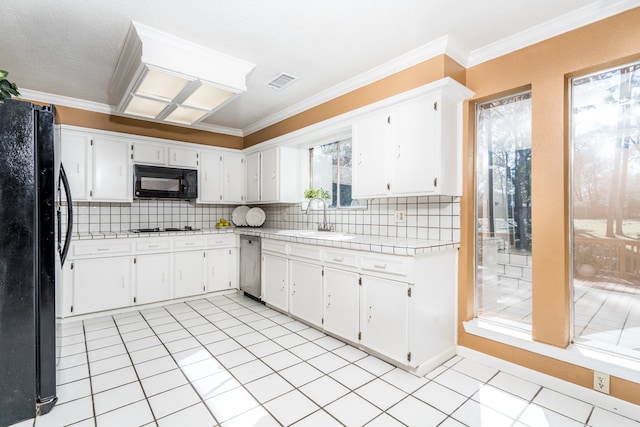 kitchen featuring light tile flooring, sink, plenty of natural light, and black appliances