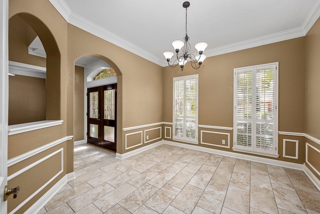 tiled empty room with crown molding, french doors, a chandelier, and a wealth of natural light