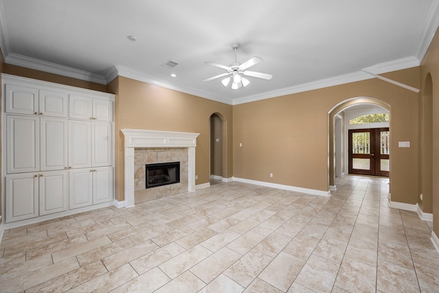 unfurnished living room featuring light tile flooring, a tile fireplace, ceiling fan, and french doors