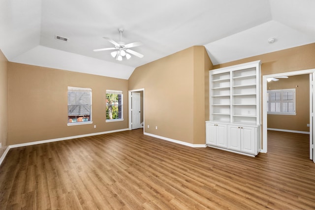 unfurnished living room with ceiling fan, built in features, light wood-type flooring, and vaulted ceiling