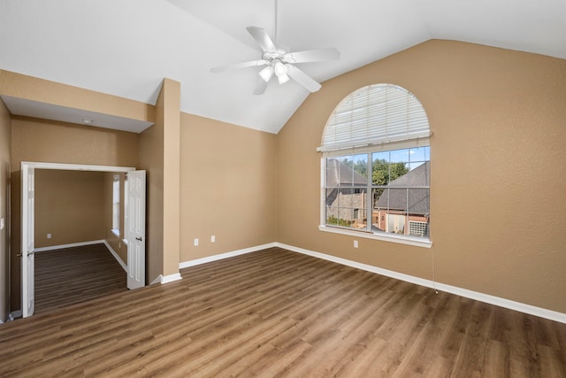 empty room with ceiling fan, lofted ceiling, and dark wood-type flooring