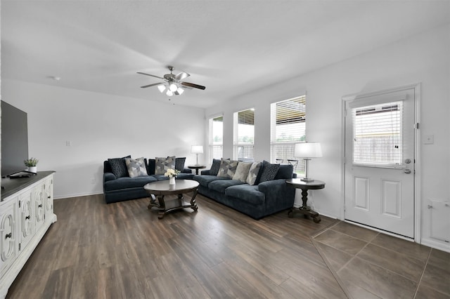 living room with dark tile flooring, ceiling fan, and a wealth of natural light