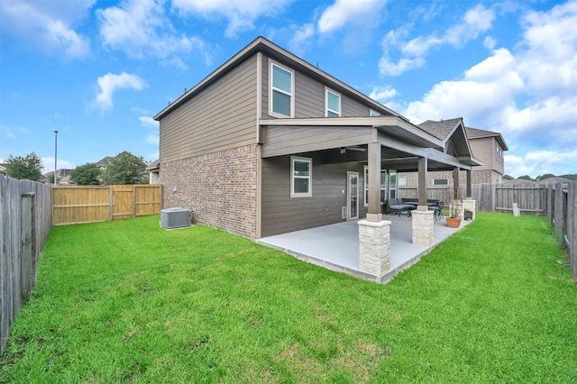 rear view of house with central AC unit, a patio, and a lawn