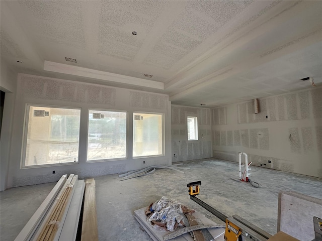 interior space with a textured ceiling and a raised ceiling