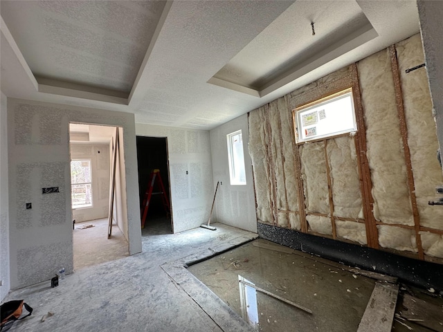 interior space with a raised ceiling and a textured ceiling