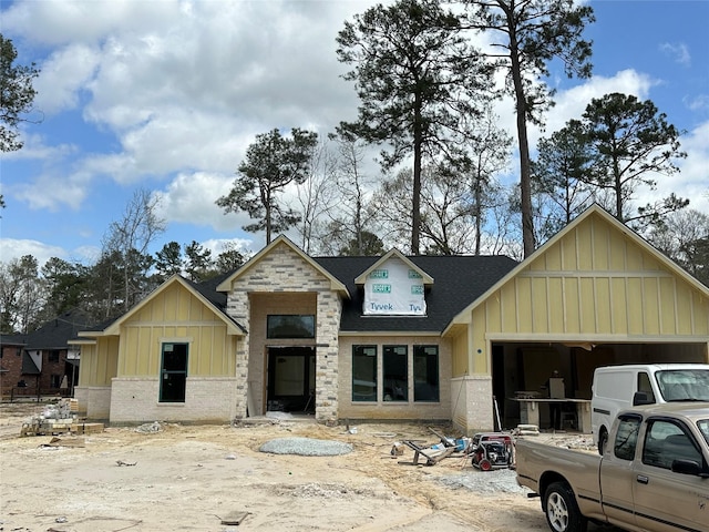 view of front of house with brick siding, board and batten siding, a shingled roof, and a garage